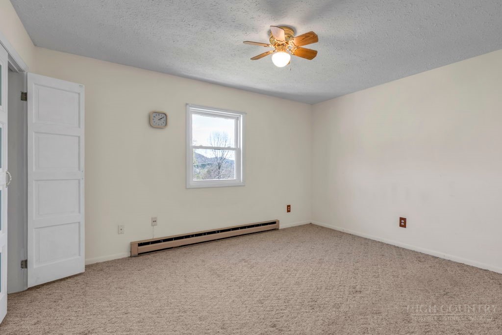 163 Rolling Hill Drive Boone, NC 28607 - Photo 19 of 40 an empty room with windows and chandelier