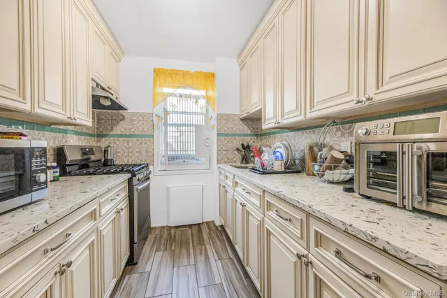 a kitchen with granite countertop a sink stainless steel appliances and cabinets
