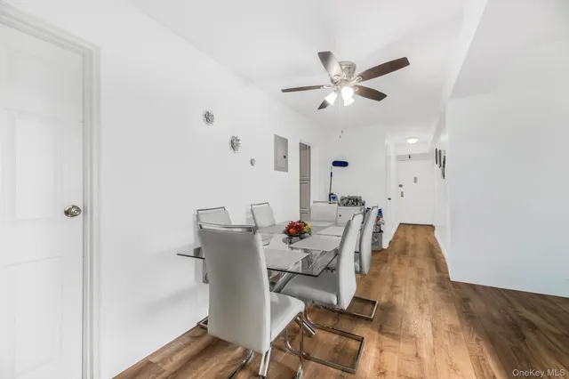 a dining room with furniture and a chandelier fan