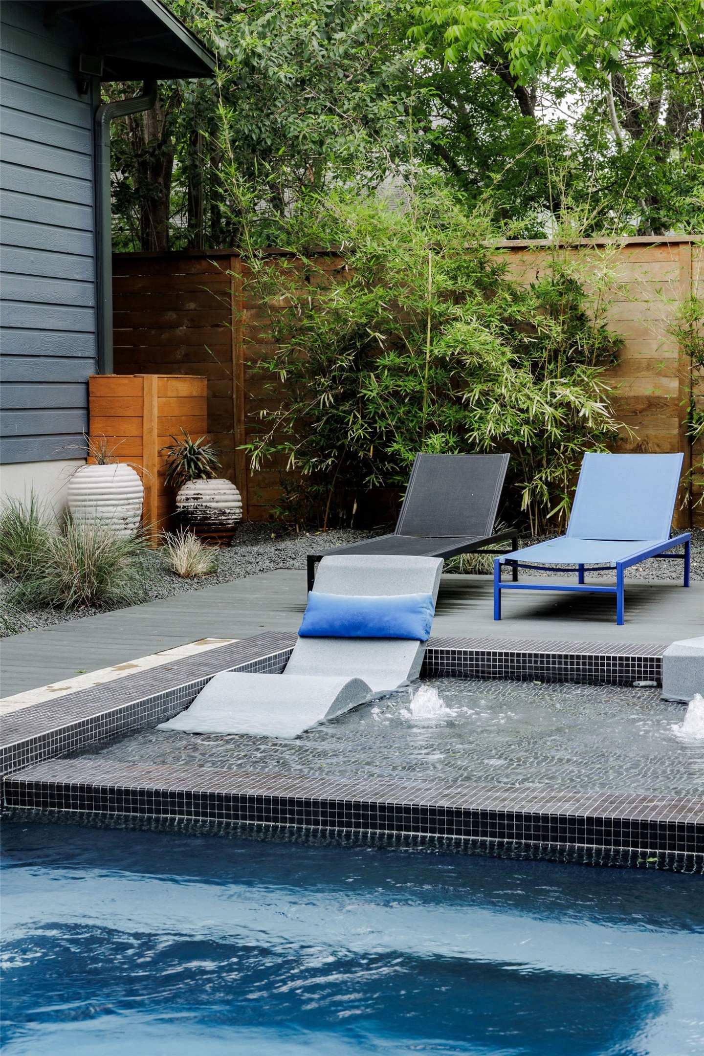 1605 Maple Avenue Austin, TX 78702 - Photo 30 of 33 Outdoor aquatic feature with integrated chaise lounge, dark tile pool surround, and multiple water jets