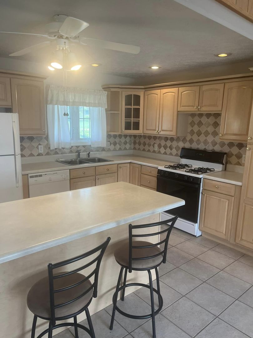 24 Brookwood Drive Normal, IL 61761 - Photo 3 of 12 a kitchen with stainless steel appliances granite countertop a stove a sink and a refrigerator