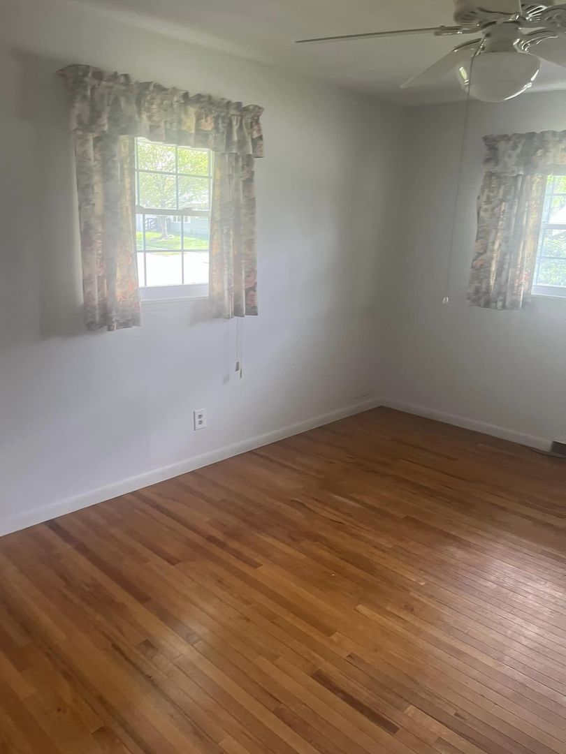 24 Brookwood Drive Normal, IL 61761 - Photo 8 of 12 an empty room with wooden floor and windows