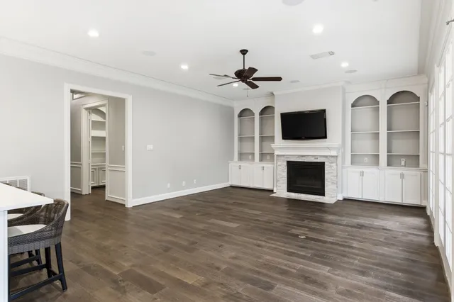 a kitchen with stainless steel appliances granite countertop a stove top oven a sink dishwasher a dining table and chairs with wooden floor