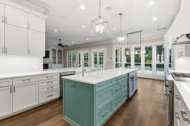 a kitchen that has a lot of cabinets in it wooden floors and a sink