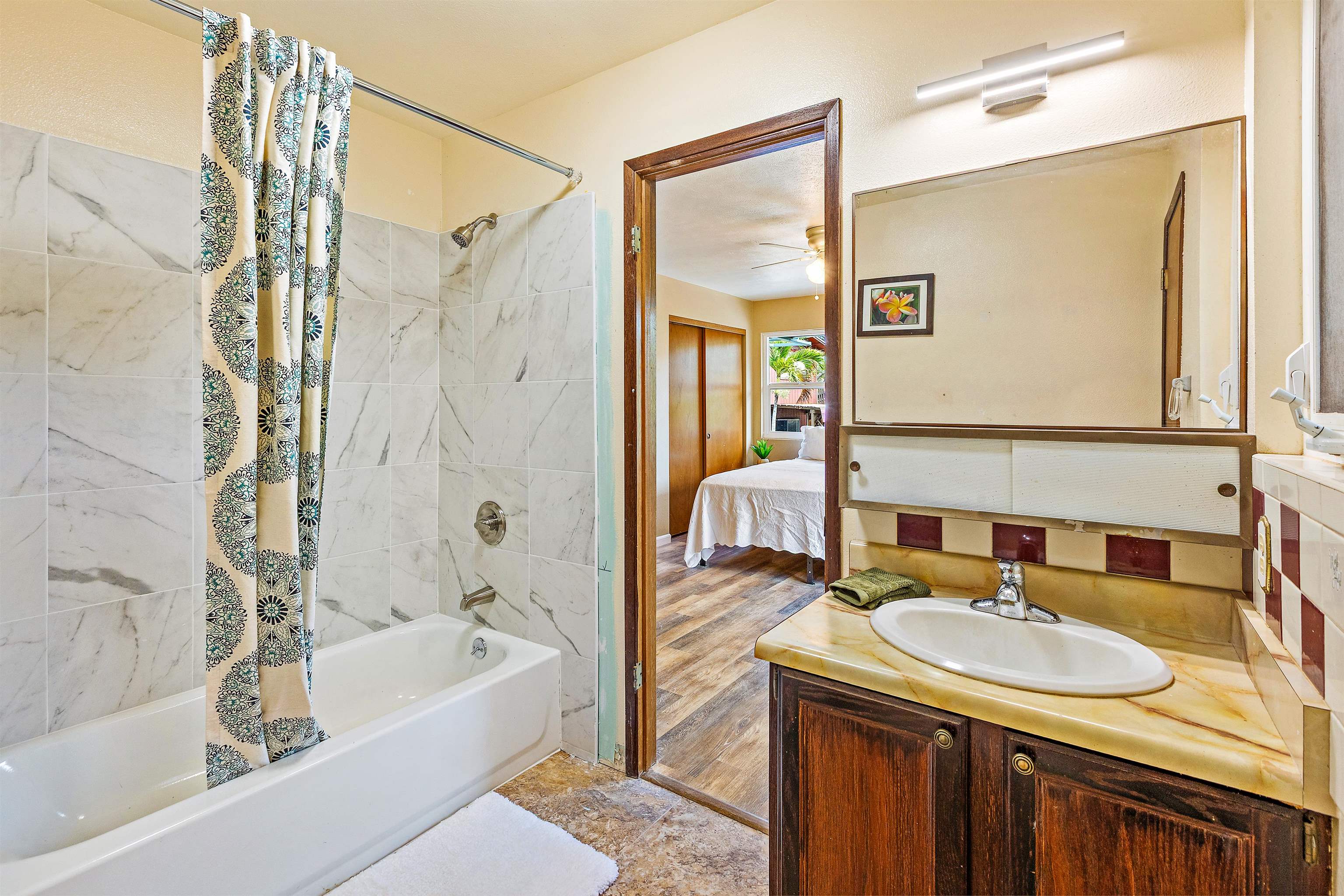 31 Pualu Loop Lahaina, HI 96761 - Photo 23 of 40 a bathroom with a granite countertop sink and a mirror a bathtub