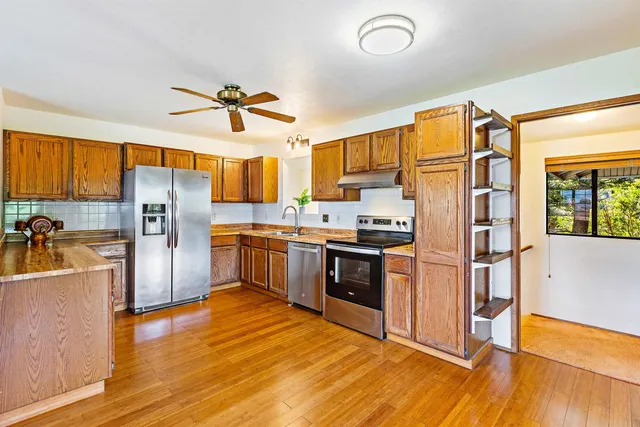 a kitchen with stainless steel appliances a refrigerator and a stove top oven