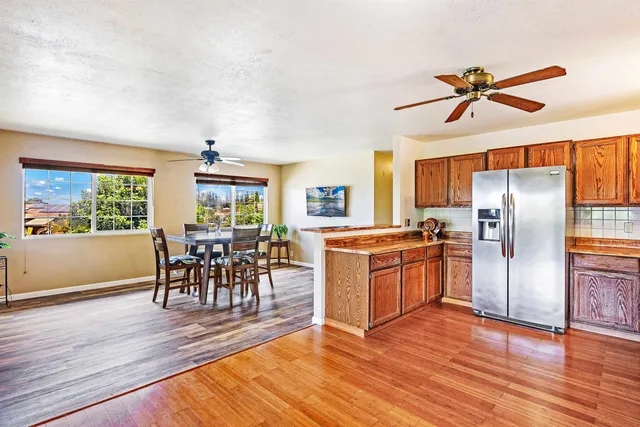a kitchen with stainless steel appliances a dining table chairs stove and refrigerator