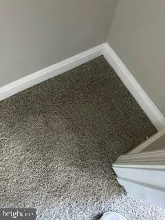 an empty room with wooden floor and natural light