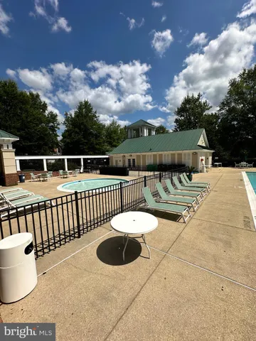 a front view of a house with swimming pool and large trees