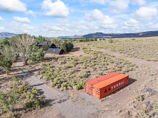 460 Omni Point Road Central Valley, UT 84754 - Photo 95 of 101 Expansive open-air property featuring a gravel driveway, mature trees, and a distant structure with a dark roof