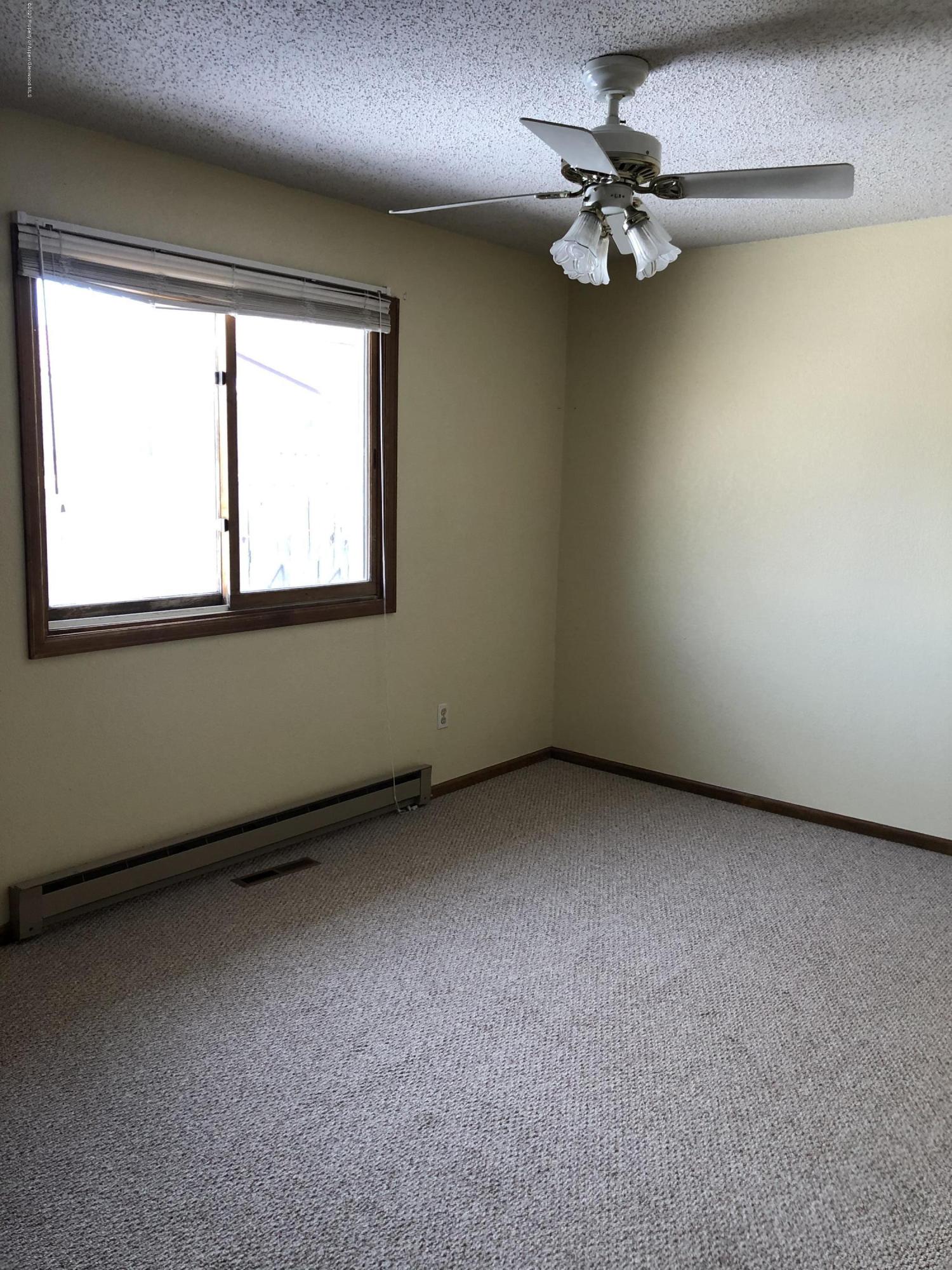 620 Elm Court Rifle, CO 81650 - Photo 10 of 16 an empty room with a chandelier fan and windows