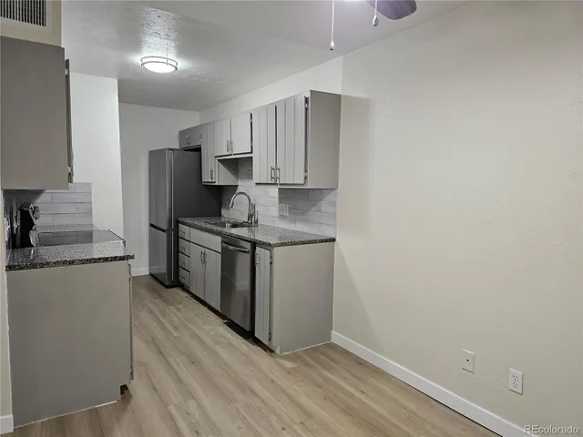 a kitchen with stainless steel appliances a sink stove and refrigerator