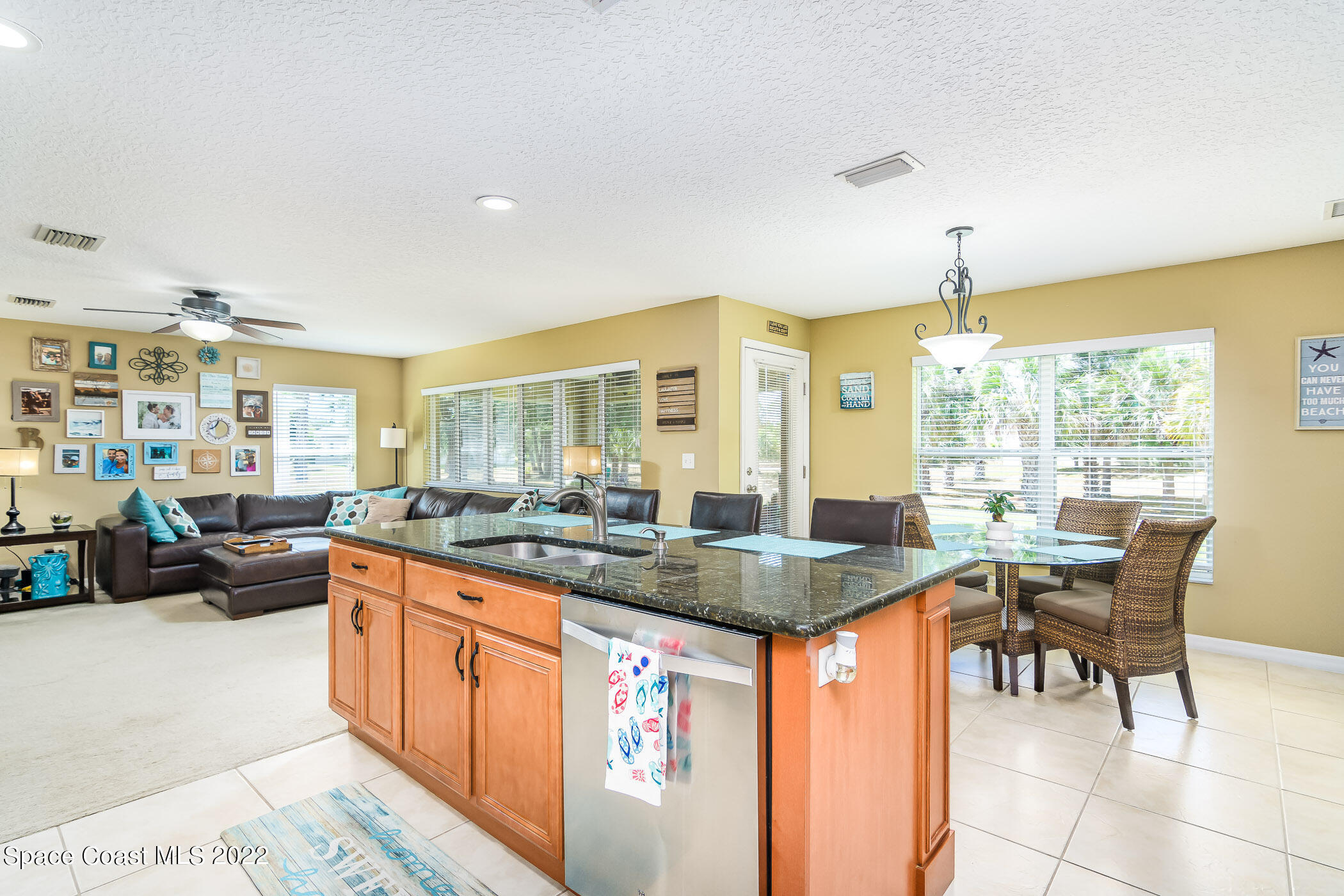 372 Franzing Street Palm Bay, FL 32908 - Photo 8 of 23 a kitchen with stainless steel appliances granite countertop table chairs and a large window