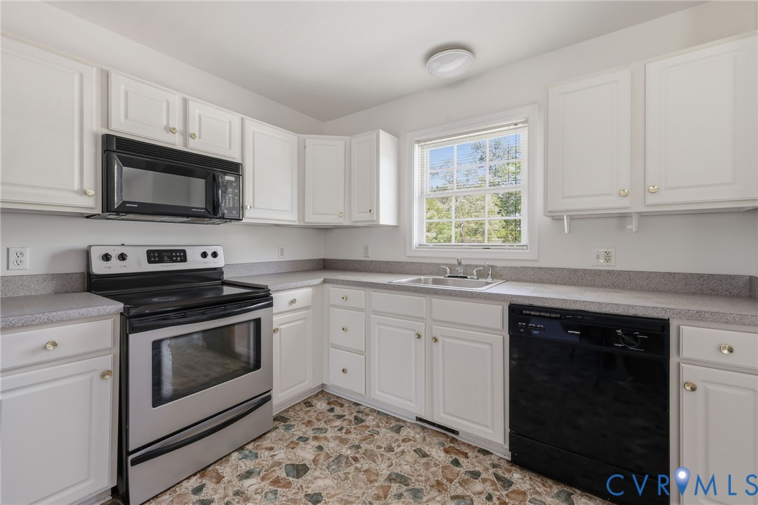 5816 Abilene Road Farmville, VA 23901 - Photo 9 of 26 a kitchen with granite countertop a stove a sink and a microwave