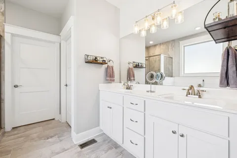 a bathroom with a double vanity sink mirror and