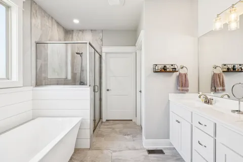 a bathroom with a tub sink and mirror