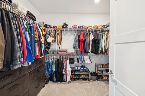 a view of walk in closet with clothes