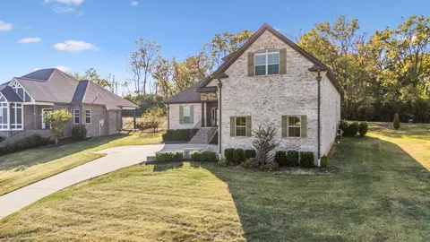 a view of house with yard and swimming pool