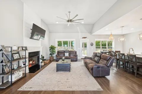 a living room with fireplace furniture and a wooden floor