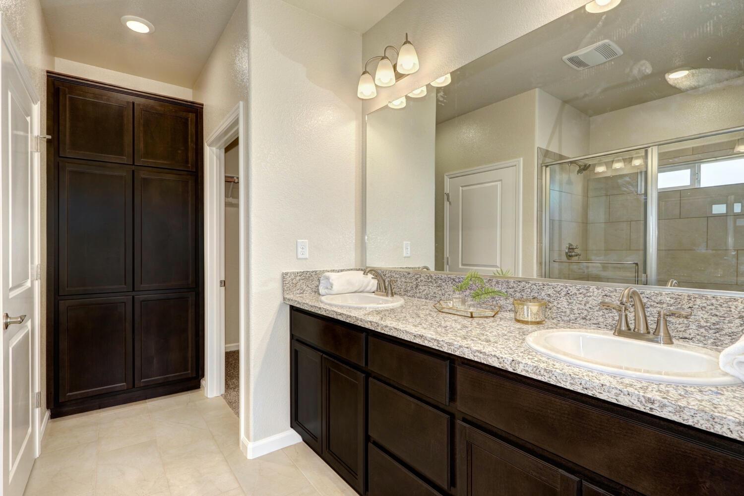 1071 Hogan Road Galt, CA 95632 - Photo 16 of 17 a bathroom with a granite countertop sink a light fixture and a mirror