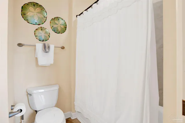 a white toilet sitting next to a white wall