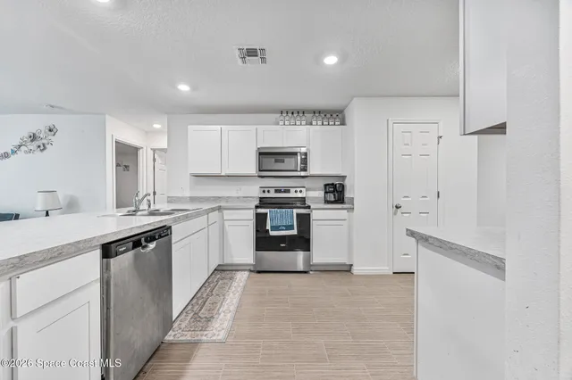 a kitchen with granite countertop a refrigerator stove and sink