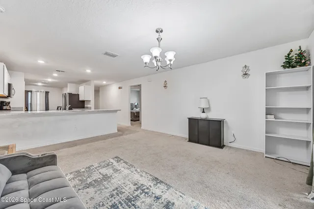 a living room with furniture and a chandelier