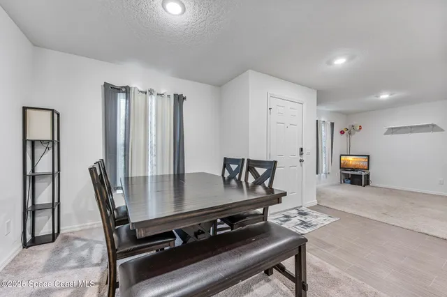 a living room with furniture a flat screen tv and a table