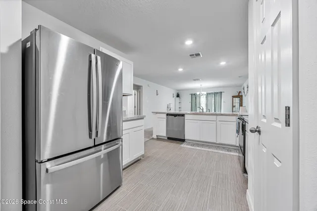 a kitchen with white cabinets and stainless steel appliances
