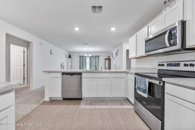 a kitchen with stainless steel appliances granite countertop a stove a microwave and a sink