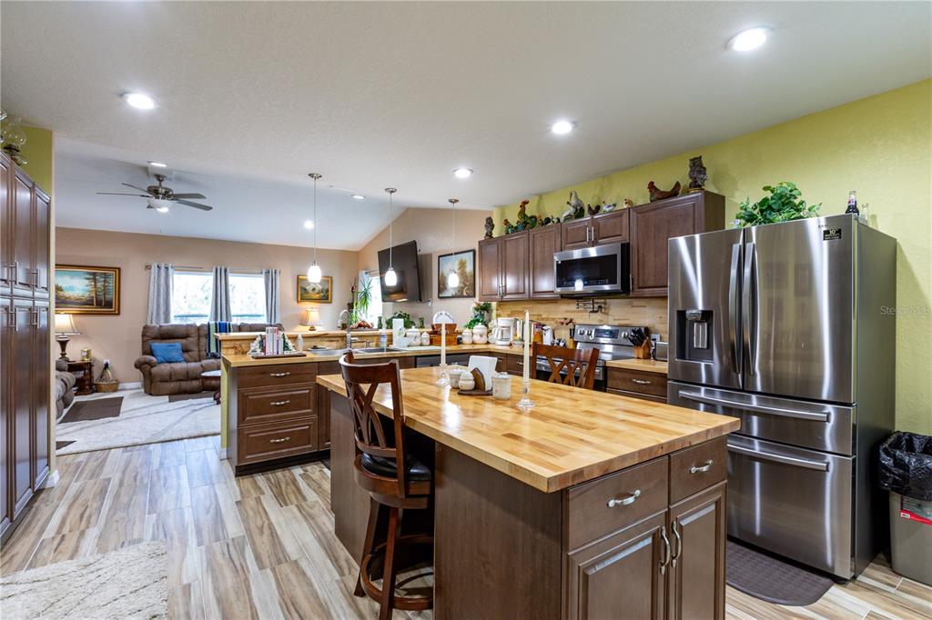 402 Southeast 709th Street Old Town, FL 32680 - Photo 9 of 37 a kitchen with a refrigerator a stove top oven a sink dishwasher and dining table with wooden floor