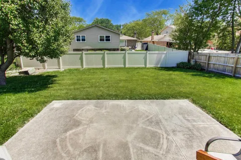 a view of backyard with a garden and trees