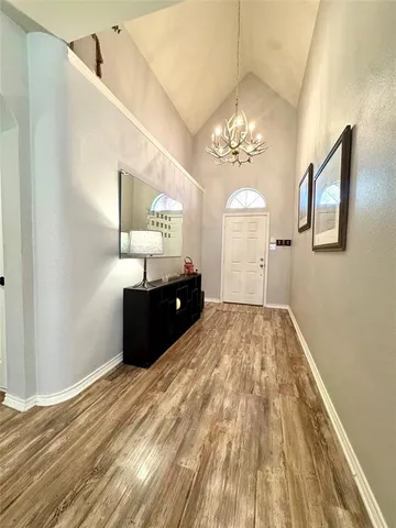 a spacious bedroom with a bed and a chandelier