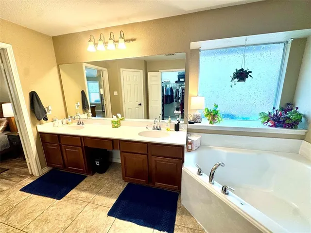 a bathroom with a tub sink and mirror