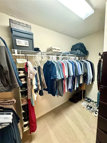 a view of walk in closet with clothes and shoes