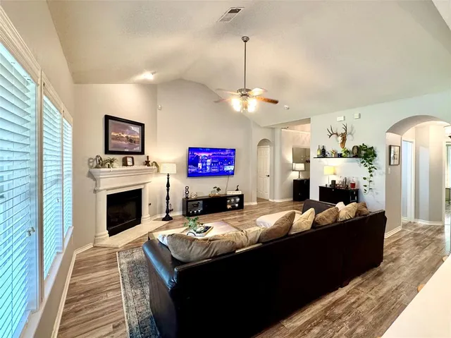 a living room with furniture a fireplace and a flat screen tv