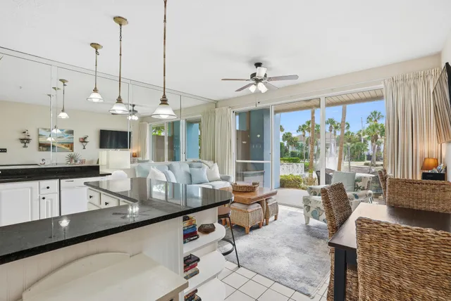 a living room with furniture a flat screen tv and kitchen view