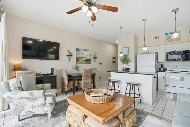 a kitchen with stainless steel appliances kitchen island granite countertop a table chairs and a refrigerator
