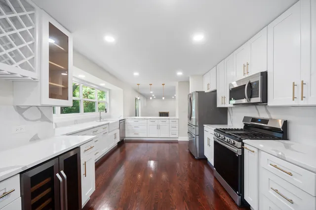 a large kitchen with stainless steel appliances granite countertop a lot of counter space and wooden floor