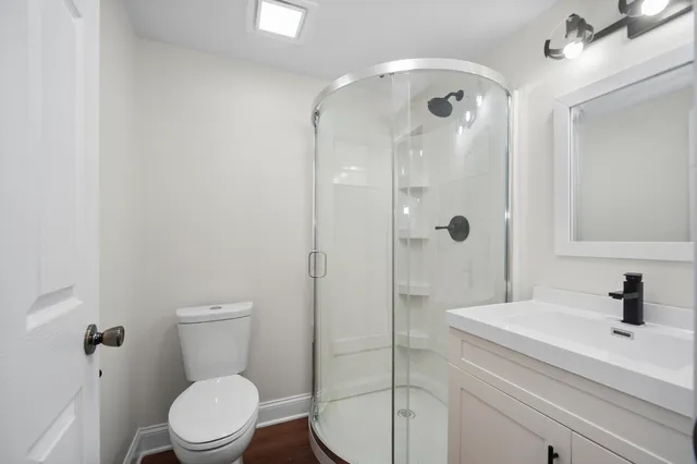 a bathroom with a sink a toilet and shower