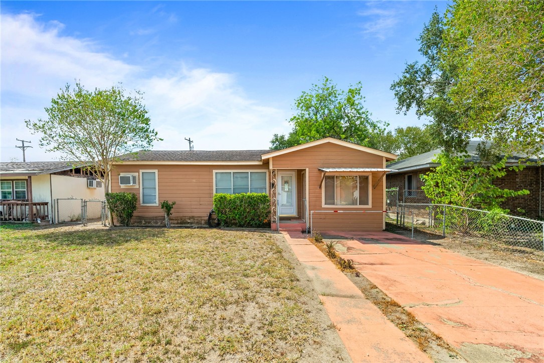 a front view of a house with a garden and yard