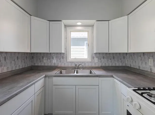 a kitchen with a sink cabinets and window
