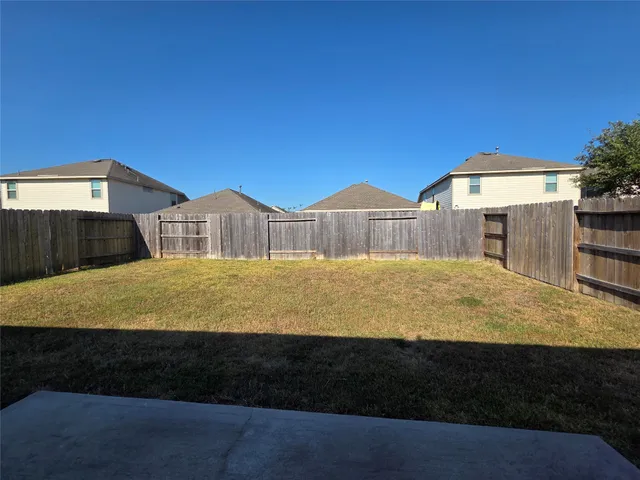a blue swimming pool is in front of a brick house