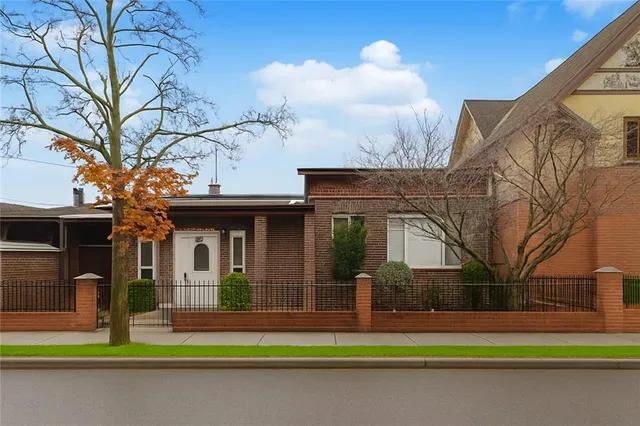 a front view of a house with a garden and plants