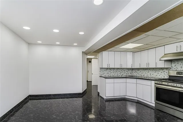 a view of a white house with many windows and plants