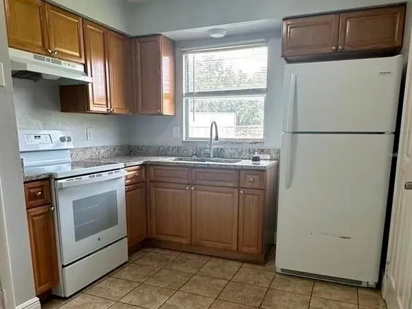 a kitchen with stainless steel appliances granite countertop a refrigerator sink and microwave