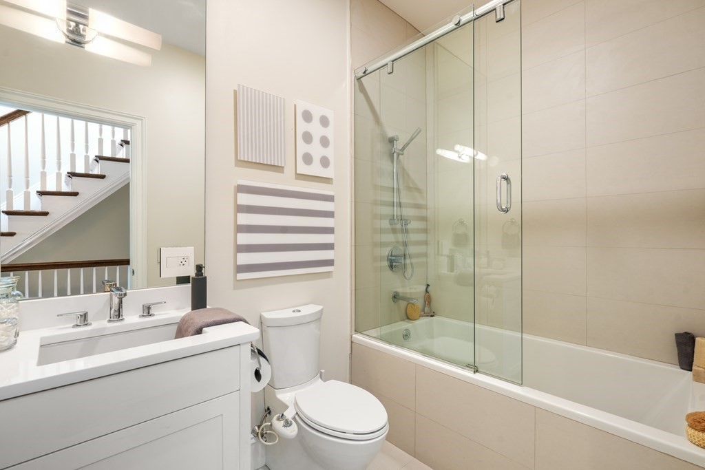 9 Columbus Square, Unit 2 Boston, MA 02116 - Photo 40 of 42 a bathroom with a bathtub shower sink vanity mirror and toilet