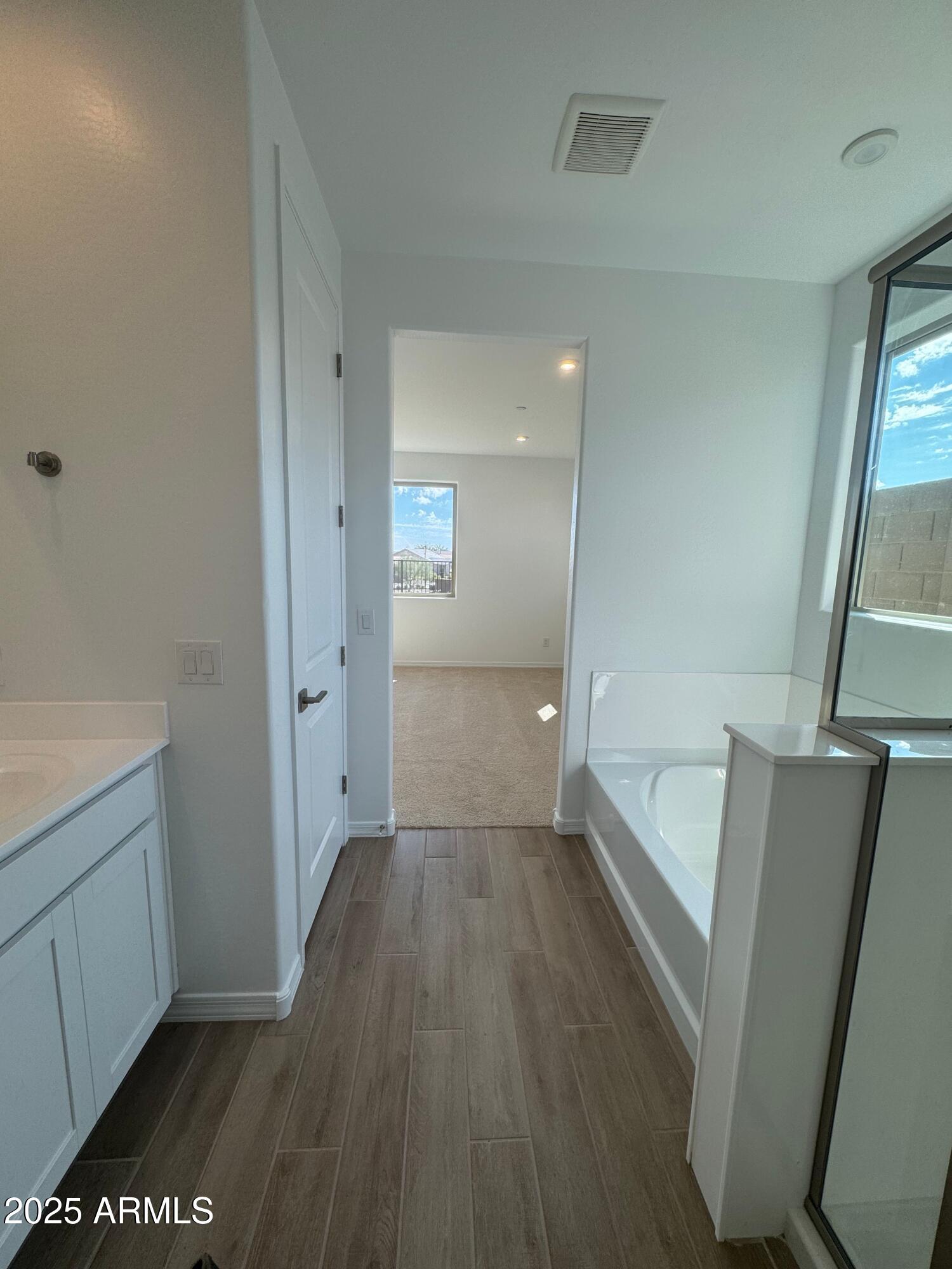 13351 West Eagle Feather Road Peoria, AZ 85383 - Photo 12 of 23 a view of an empty room with wooden floor and a window