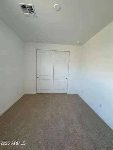 a view of an empty room and chandelier fan