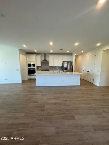 a large kitchen with stainless steel appliances granite countertop a large counter top and a stove top oven